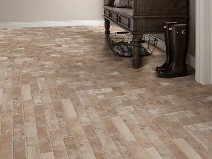 Rustic Brick-Style Flooring in Neutral Room with Wooden Bench and Boots Rustic brick-style flooring in a neutral-toned room with a dark wooden bench and boots