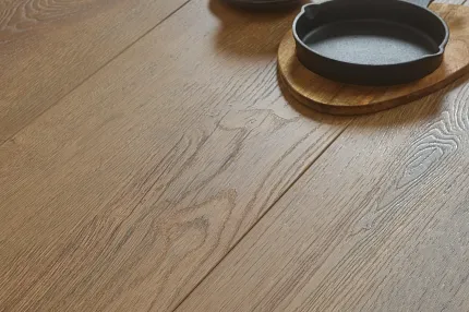 Close-up of wood look luxury vinyl plank floor with a natural oak finish with a black cup and skillet on a wooden board Natural Oak Wood Look Luxury Vinyl Plank Flooring - Durable and Stylish LVP