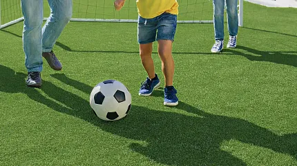 Durable artificial turf for outdoor play areas Children playing soccer on artificial grass