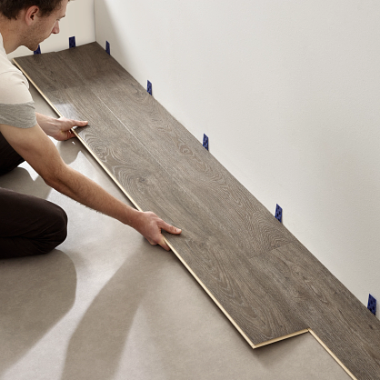man installing coretec vinyl plank flooring