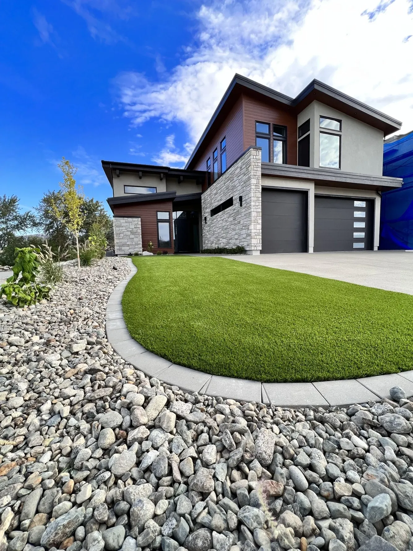 Modern house exterior with stone landscaping and green lawn