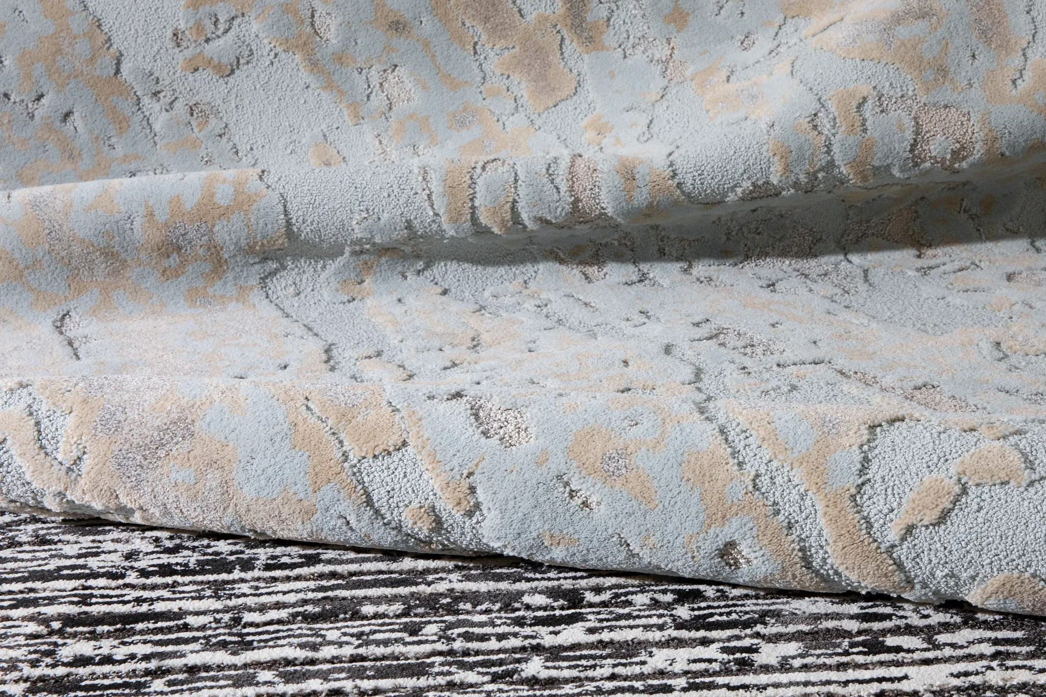 Close-up of a textured carpet swatch in light blue and beige colors