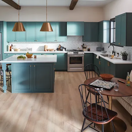 Contemporary kitchen design with durable light wood flooring and teal cabinetry Modern kitchen with teal cabinets, brass pendant lights, and light wood flooring