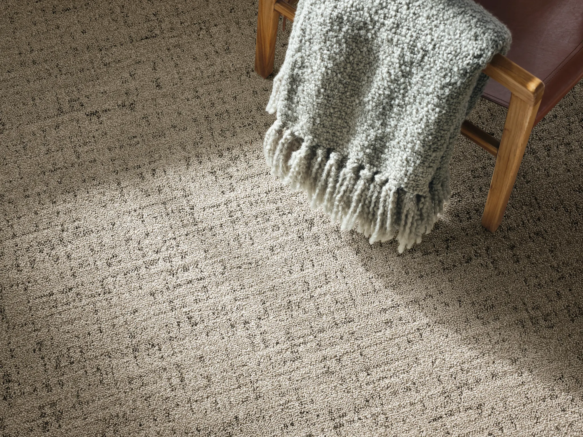 Blue and beige checkered carpet with light hardwood flooring and brown shoes