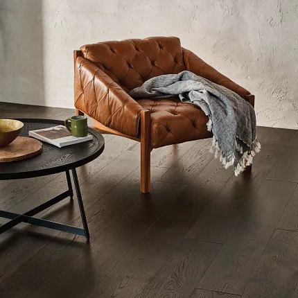 Premium Dark Hardwood Flooring for Contemporary Interiors Elegant dark hardwood flooring in a modern living room with a leather armchair and round coffee table