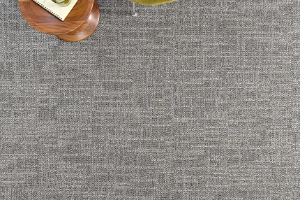 Modern room with gray commercial carpet tile and green chair, 24x24 inch dimensions Overhead view of a modern room with a green chair and wooden side table on a gray commercial carpet tile, 24x24 inch dimensions