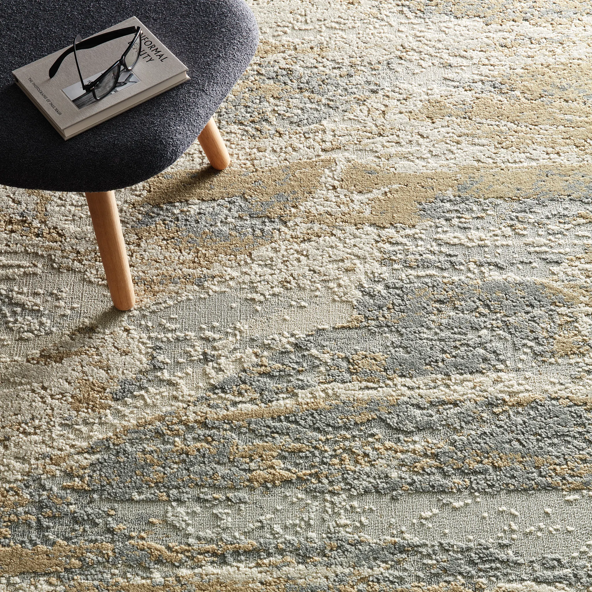 Textured commercial carpet tile in shades of beige, gray, and cream with a modern abstract pattern