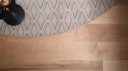 Light Hardwood Flooring with Beige and Gray Carpet Light hardwood flooring with a round beige and gray patterned carpet