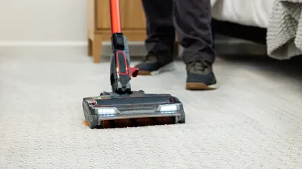 Easy-to-maintain carpet for everyday comfort Vacuuming soft surface carpet in a cozy bedroom