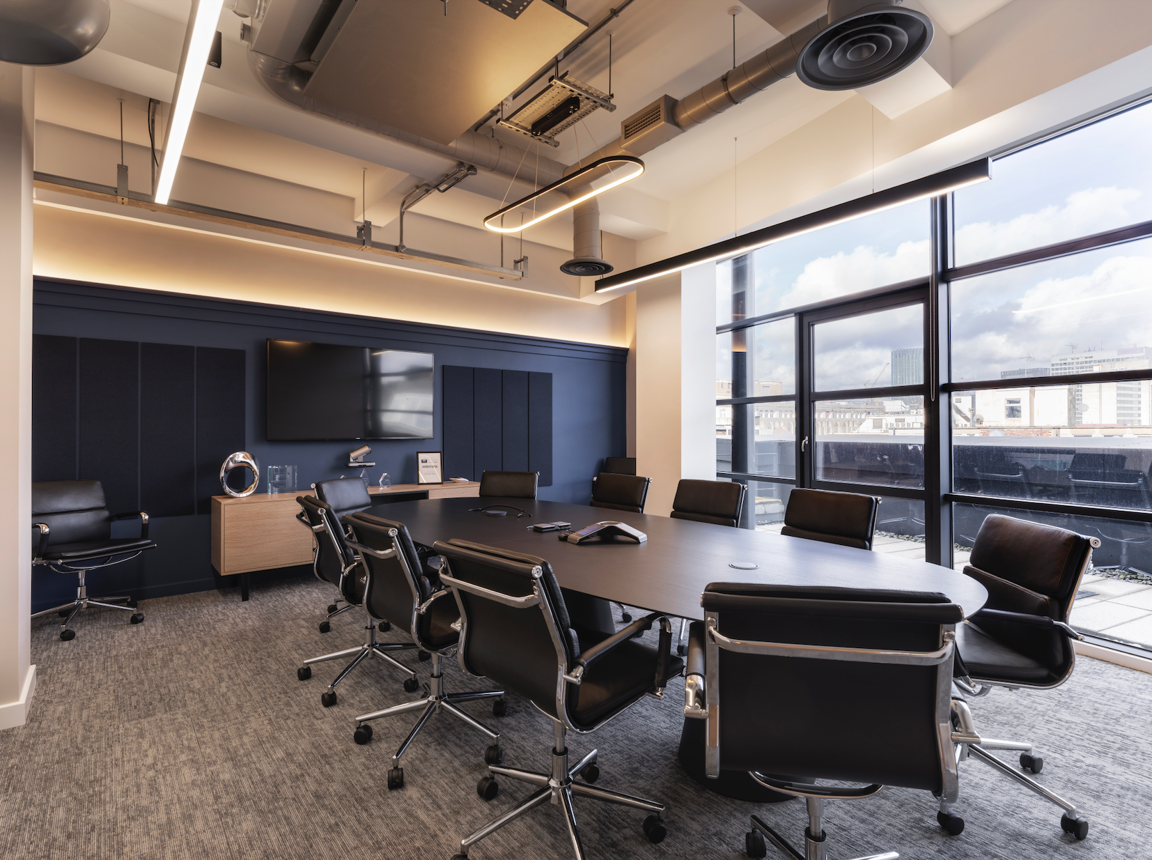 Modern conference room with large windows and sleek black chairs on commercial carpet tile flooring