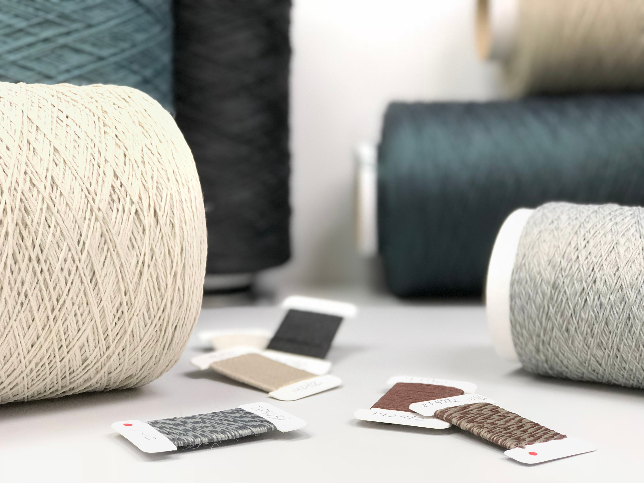 
  "Yarn spools and carpet swatches in various colors"
)