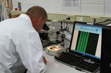 Precision analysis in scientific research laboratory Laboratory technician analyzing samples under a microscope
