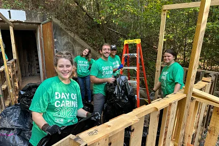 Community service event with participants in green shirts Group of people participating in a community service event wearing green "Day of Caring 2023" shirts