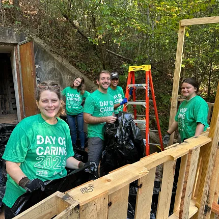Community service event with participants in green shirts Group of people participating in a community service event wearing green "Day of Caring 2023" shirts