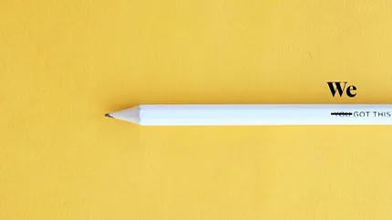 Motivational image with white pencil on yellow background White pencil on yellow background with motivational text "We Got This"