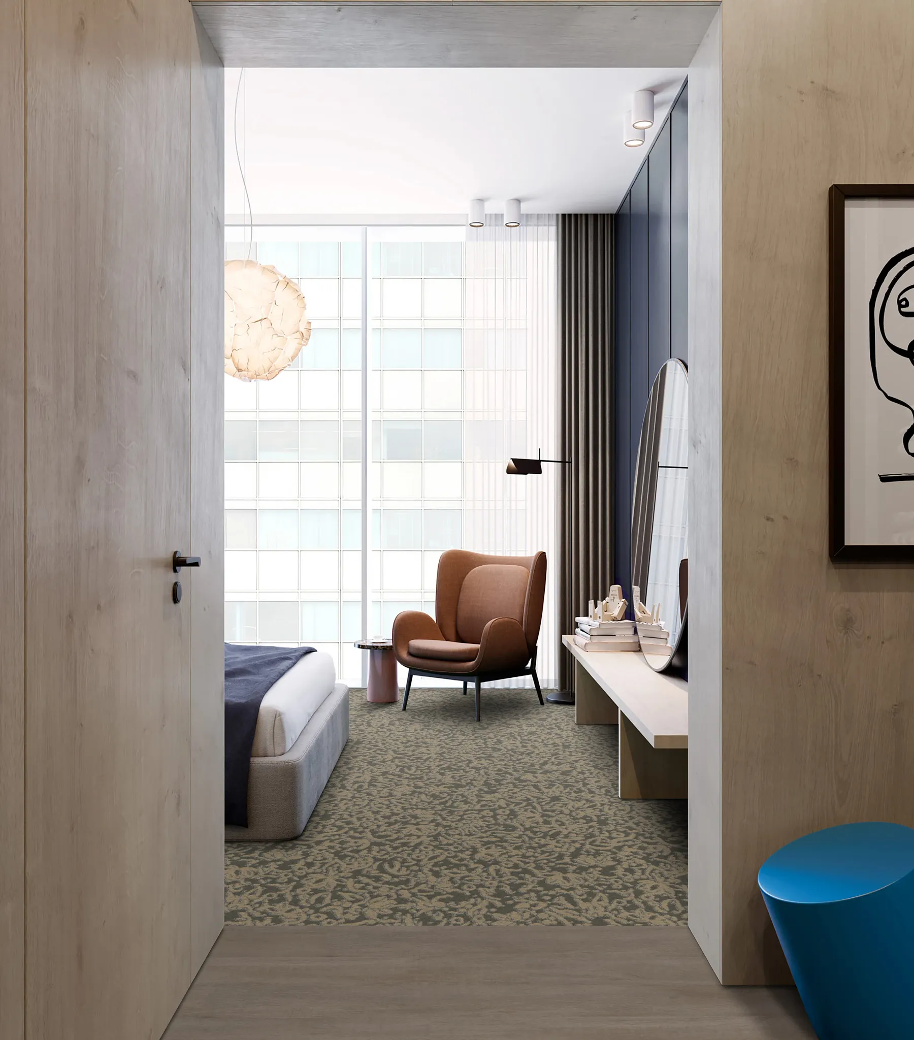 Modern hotel room with patterned commercial carpet tile, featuring a brown armchair and large window