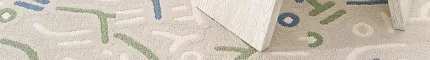 Beige carpet with blue and green abstract design under white table with decor items Keith in Fresco