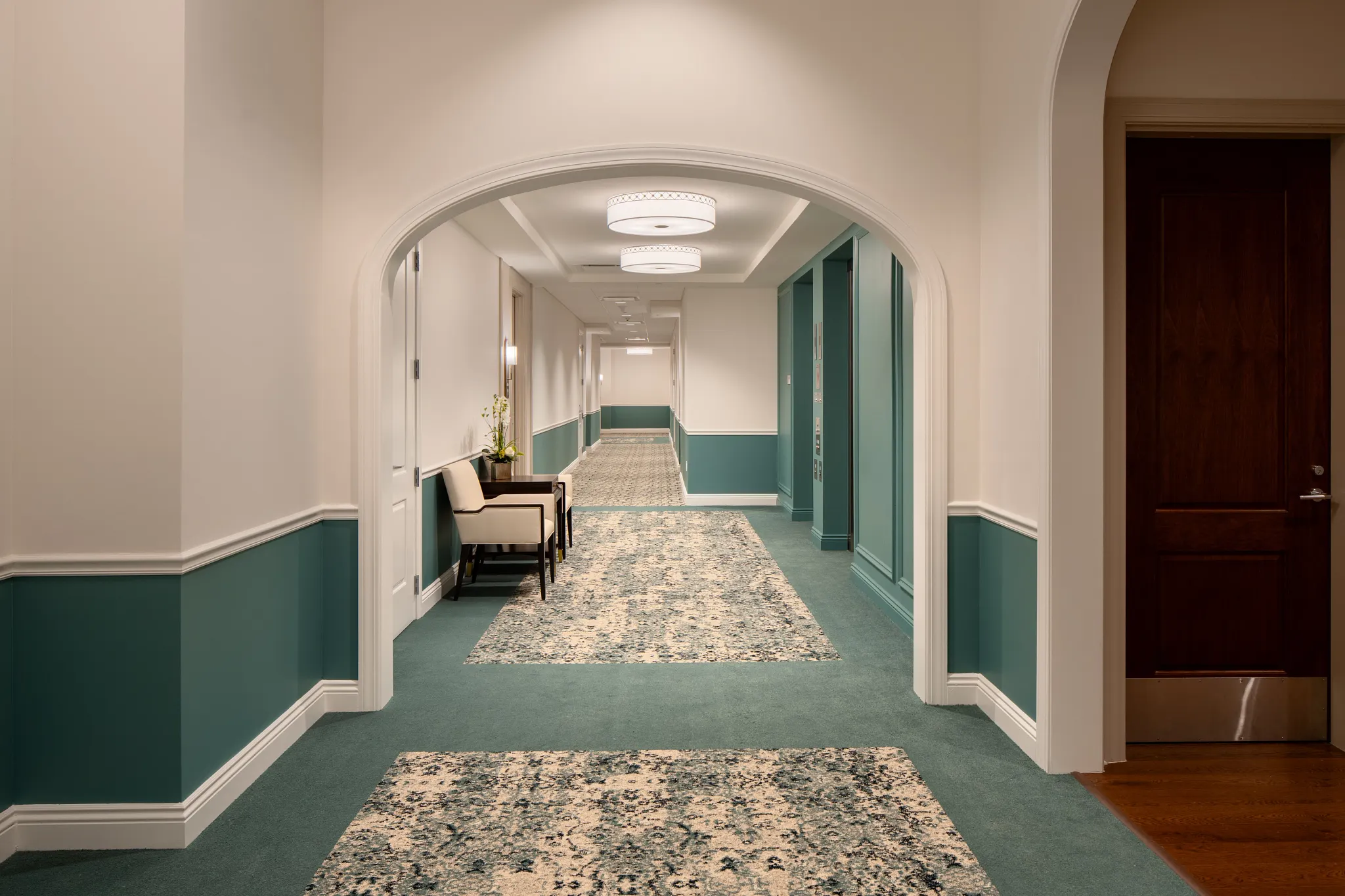Elegant hallway with patterned carpet and teal wall accents