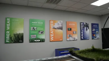 Educational posters on fiber durability and weather impact in flooring showroom Showroom display of informational posters on fiber wear and weather analysis