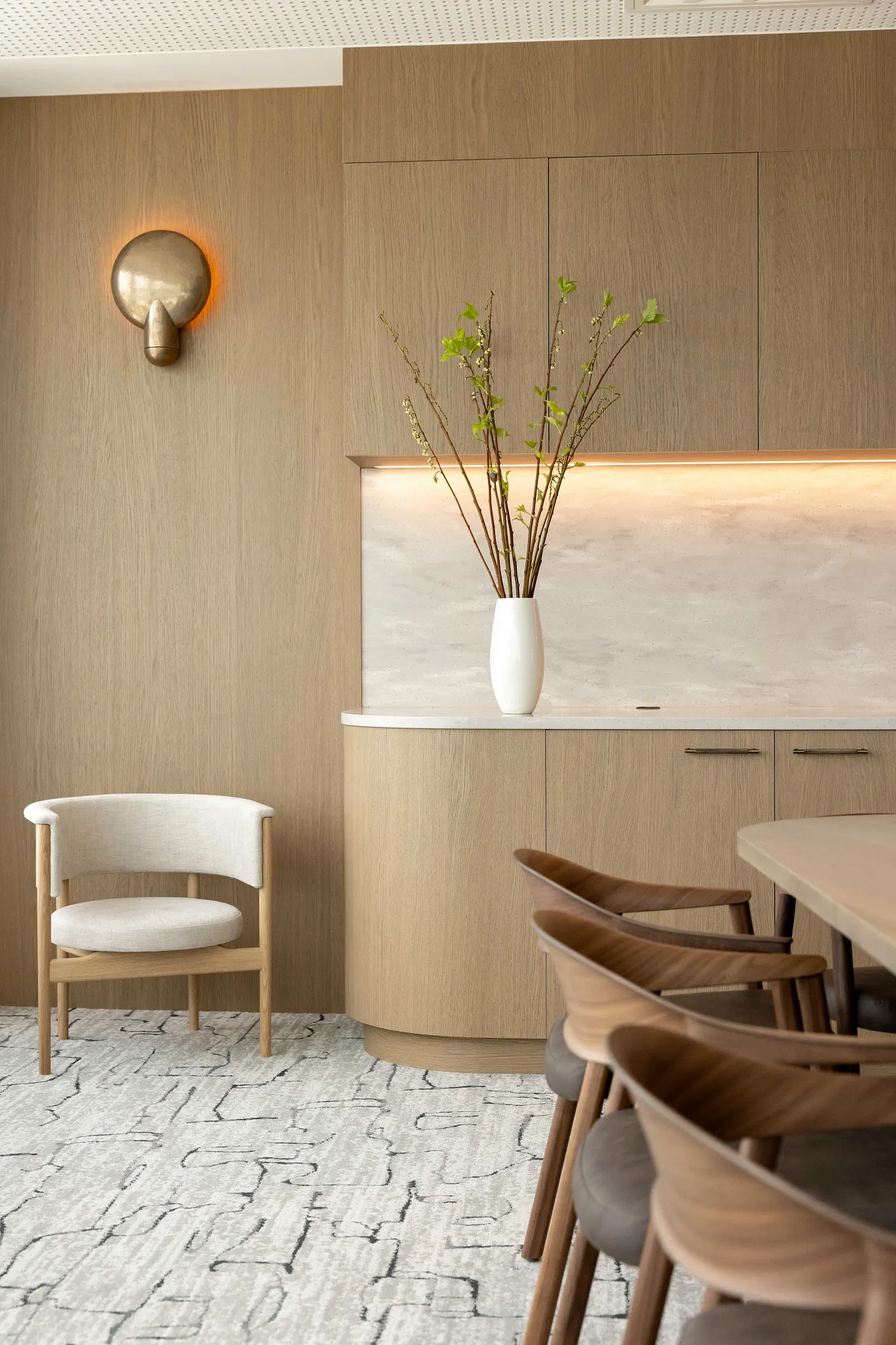 Modern dining room with light wood cabinetry and abstract patterned carpet