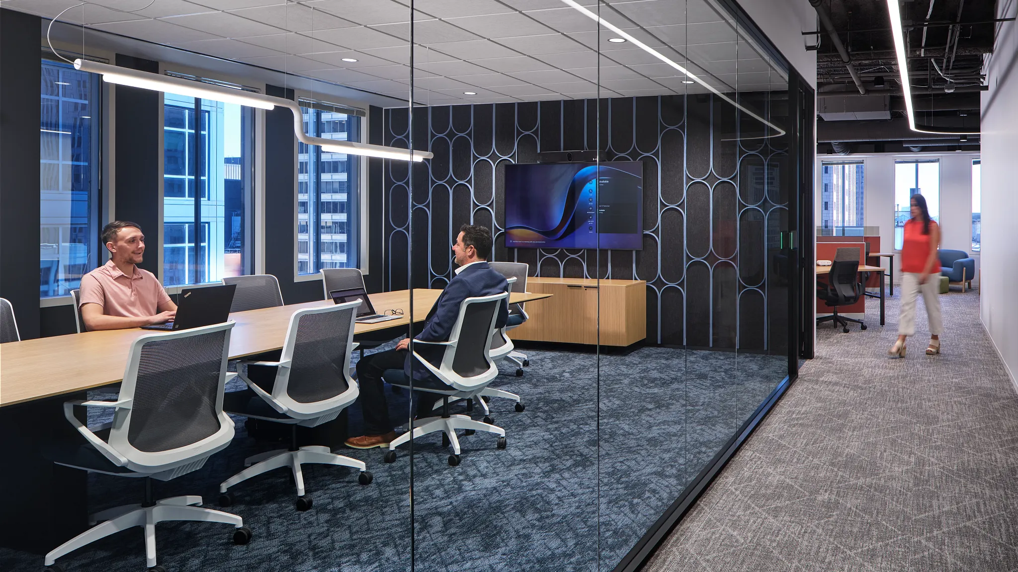 Conference room with blue carpet tile transitioning to a corridor with grey carpet tile