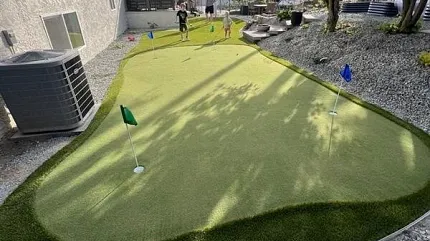 Outdoor artificial turf for golf practice Backyard putting green with flags and people