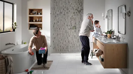 Coretec Residential WPC Luxury Vinyl Tile Flooring in Modern Bathroom Scene Modern bathroom with Coretec Residential WPC luxury vinyl tile flooring in a light stone look, featuring a family scene with a young child playing and an adult at the vanity