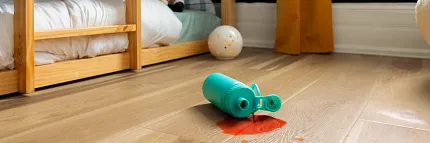Durable and waterproof vinyl flooring for family spaces Coretec Residential WPC vinyl flooring in a child's room with spilled drink