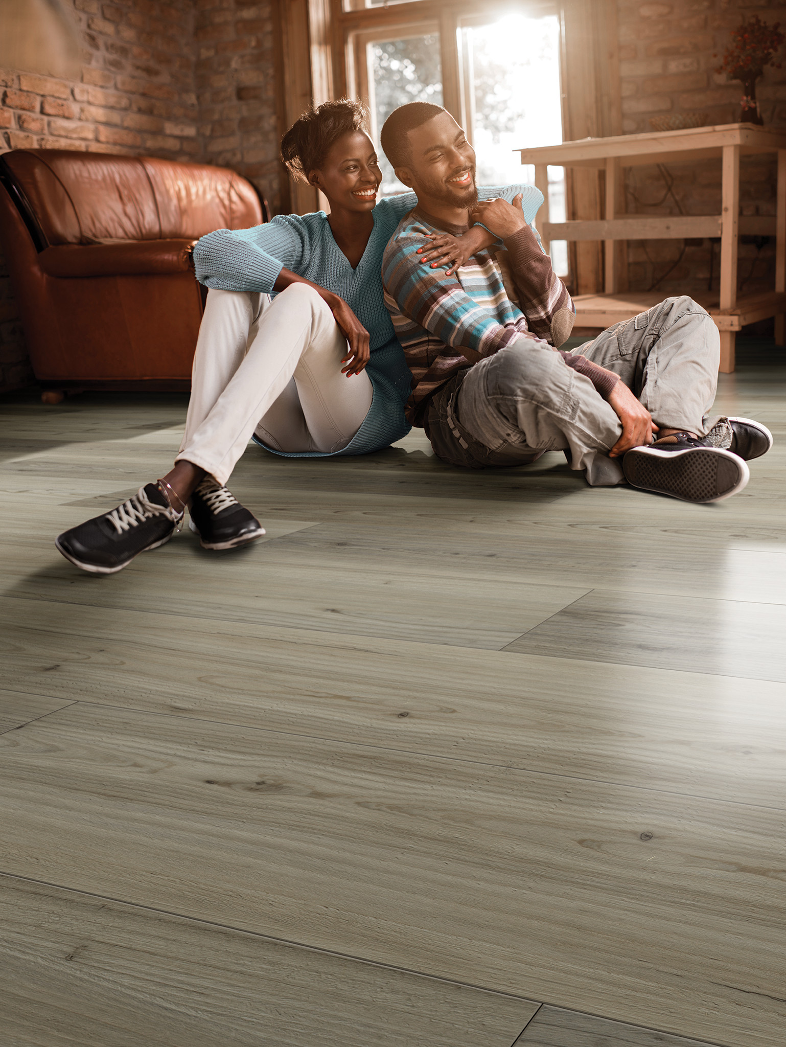 A couple sitting on a gray luxury vinyl tile floor