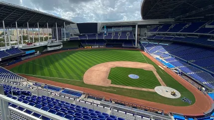 Baseball stadium with artificial turf field and blue seating Aerial view of a baseball stadium with artificial turf field and blue seating
