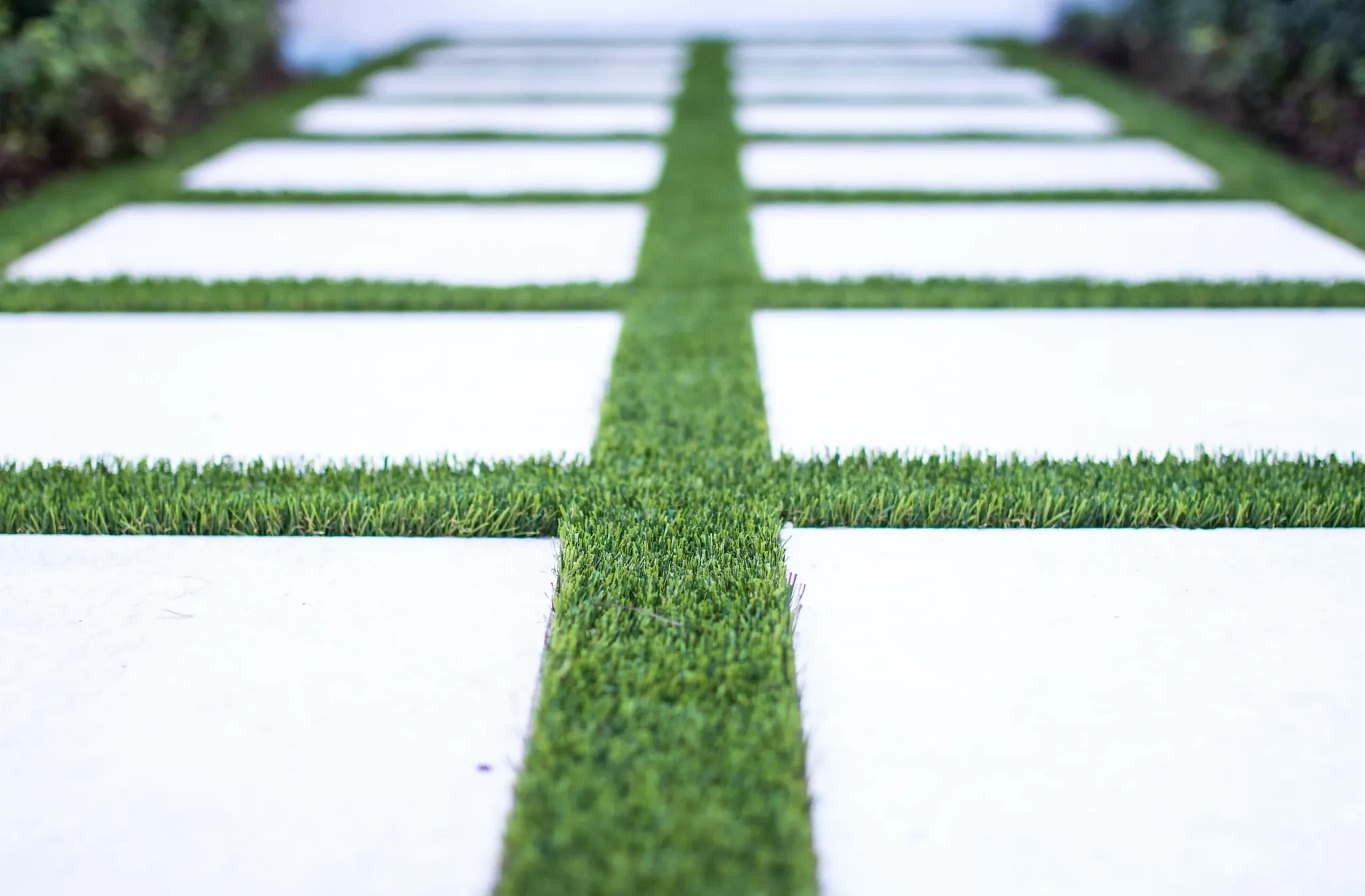 Modern outdoor walkway with artificial grass and concrete tiles