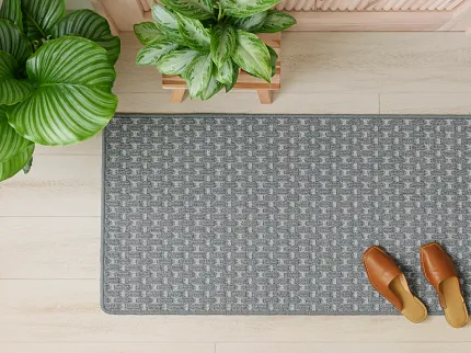 Gray Patterned Carpet Runner for Home Entryway Top view of a gray patterned carpet runner in a home entryway with wooden shoes and green potted plants