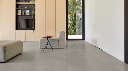 Contemporary Living Room with Gray Luxury Vinyl Tile Flooring Modern living room with large gray luxury vinyl tile flooring, light wood cabinetry, and minimalist furniture