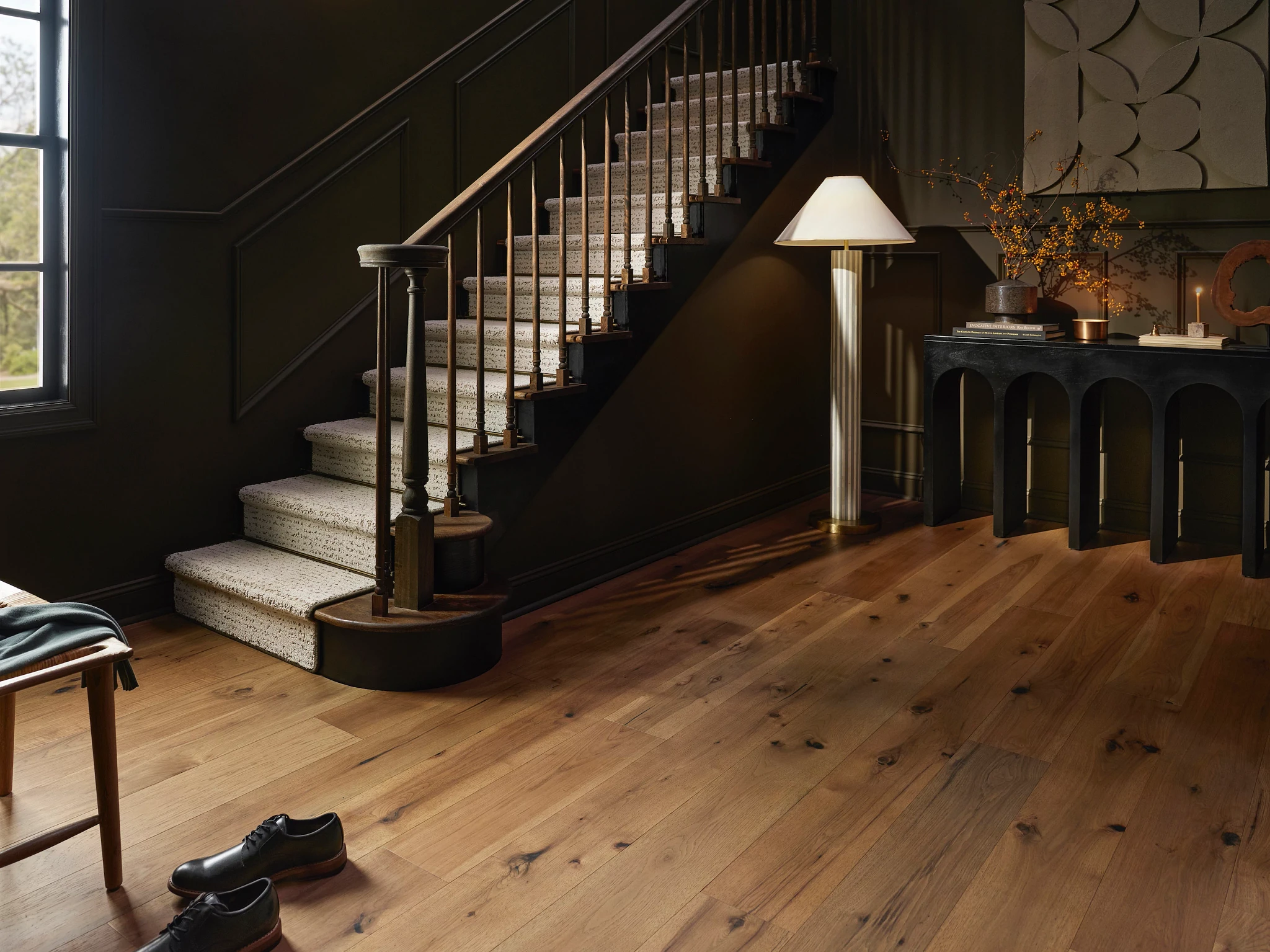 Elegant hardwood flooring in a modern entryway with a staircase and decorative elements