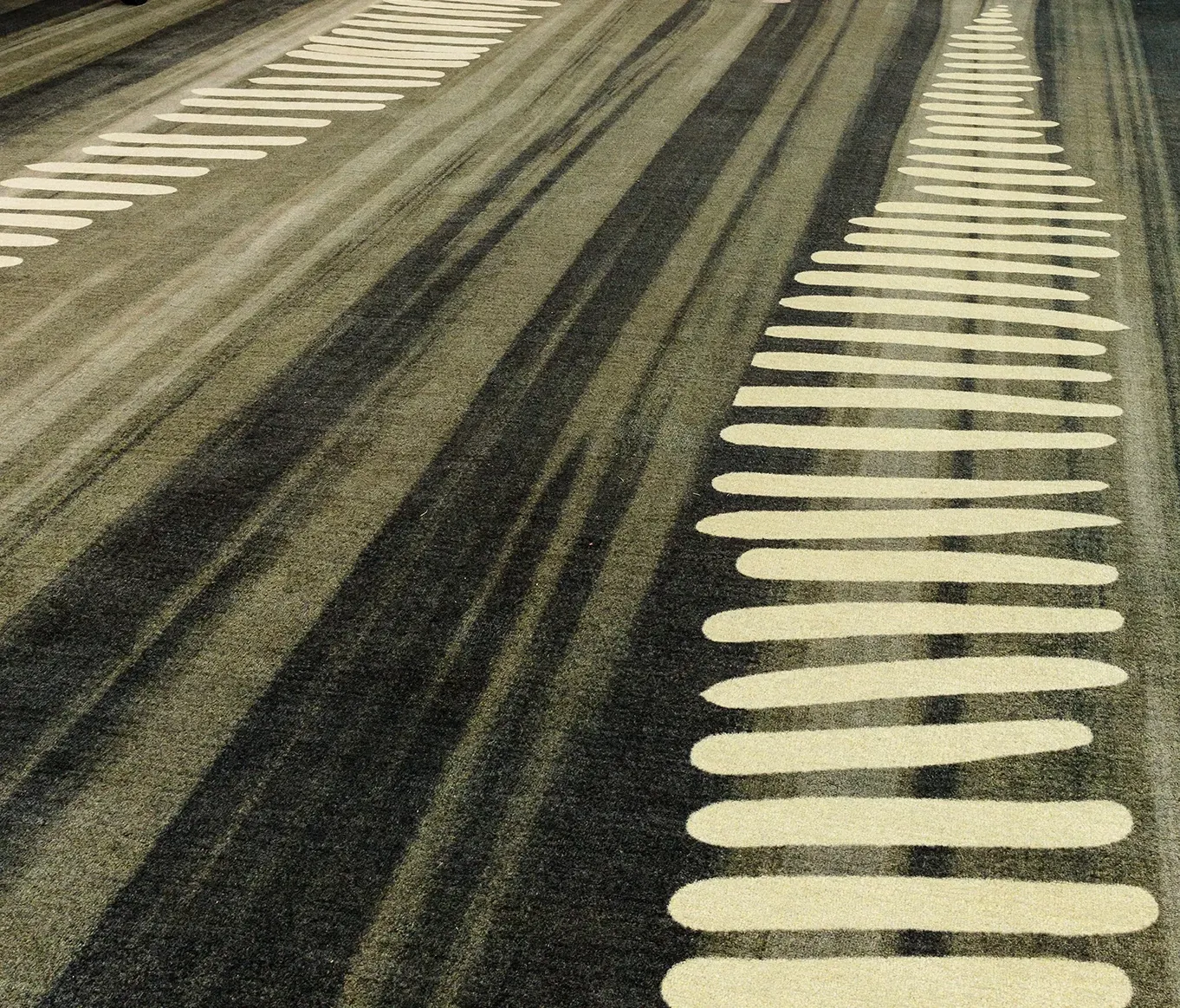 Close-up of custom carpet flooring within the University of Tasmania library, featuring layered grey tones and organic linear patterns inspired by Indigenous storytelling.