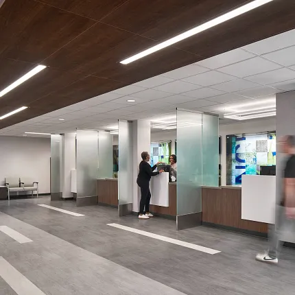Healthcare Facility Lobby with Commercial LVT Flooring in Gray Tones Modern healthcare facility lobby with commercial LVT flooring in gray tones, featuring a reception area and people interacting
