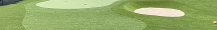 Artificial grass putting green with sand trap in outdoor setting
