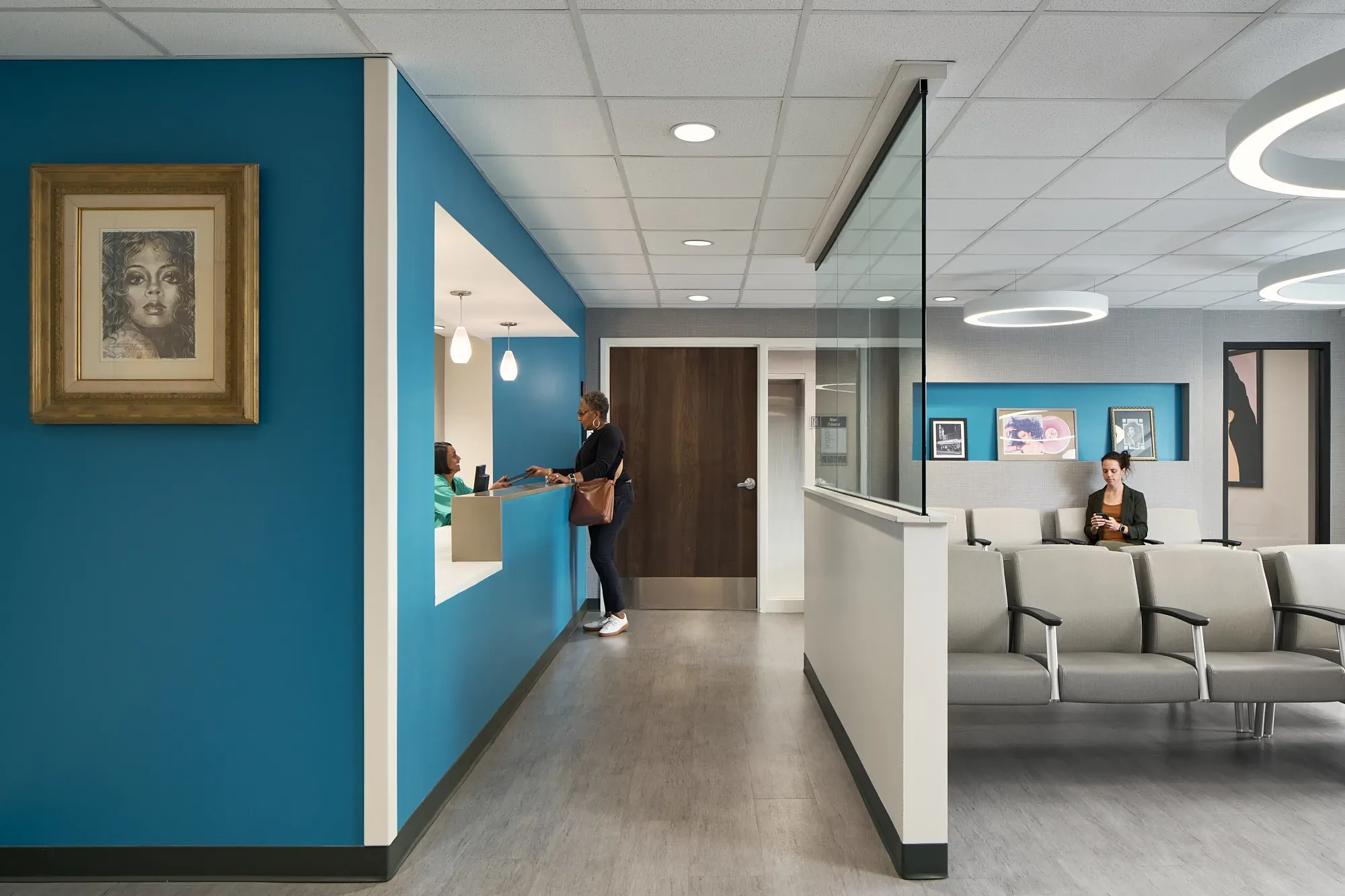 Healthcare facility waiting area with modern seating and blue accent walls, featuring commercial flooring.