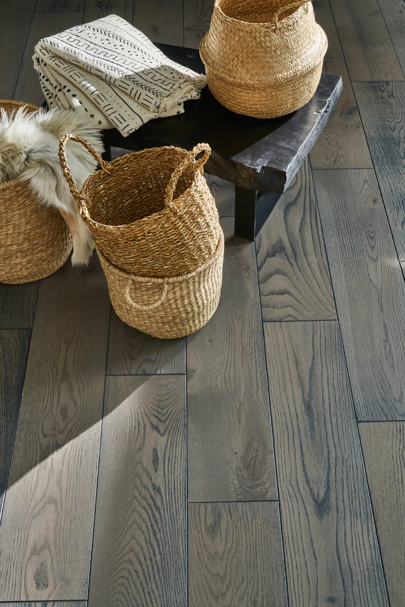 Engineered Ply-Core hardwood flooring with natural wood grain texture and woven baskets