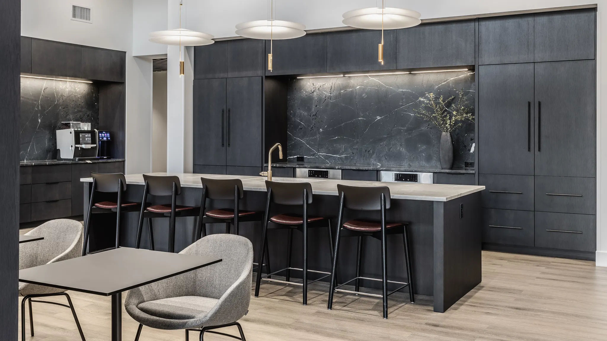 break room with an island, private seating, and a coffee machine