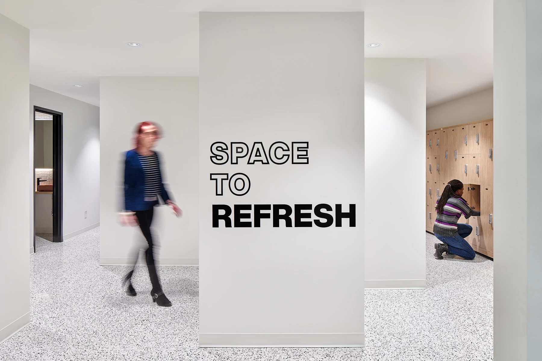 Modern workplace hallway with terrazzo flooring and lockers