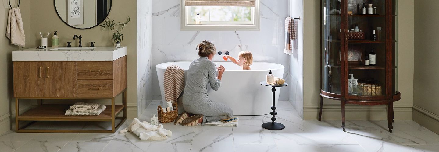 woman and child beside a bathtub after bathing with a towel and a beautiful stone floor