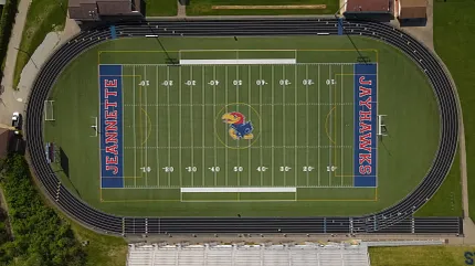 Football field and track from above Aerial view of a football field with track and surrounding buildings