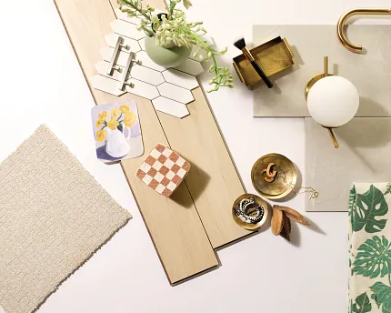 Versatile Flooring Options for a Comfortable Home - Laminate, Carpet, Tile, and Stone Samples. A flat lay of various flooring samples including light wood laminate planks, beige carpet swatch, white hexagonal tiles, and gray stone tile