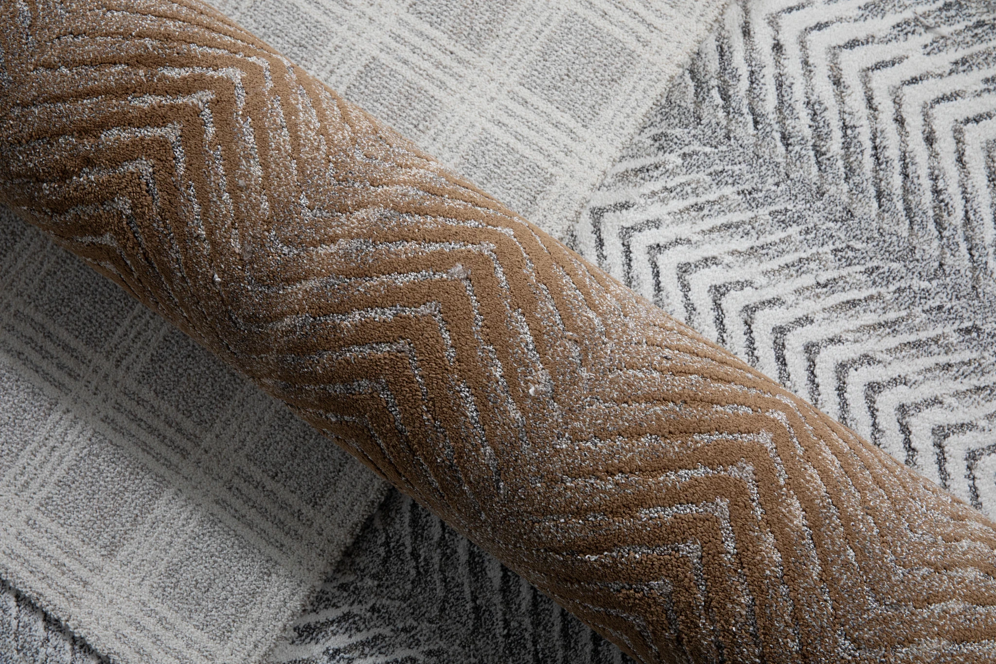 Carpet swatch featuring chevron and plaid patterns in brown, gray, and white colors