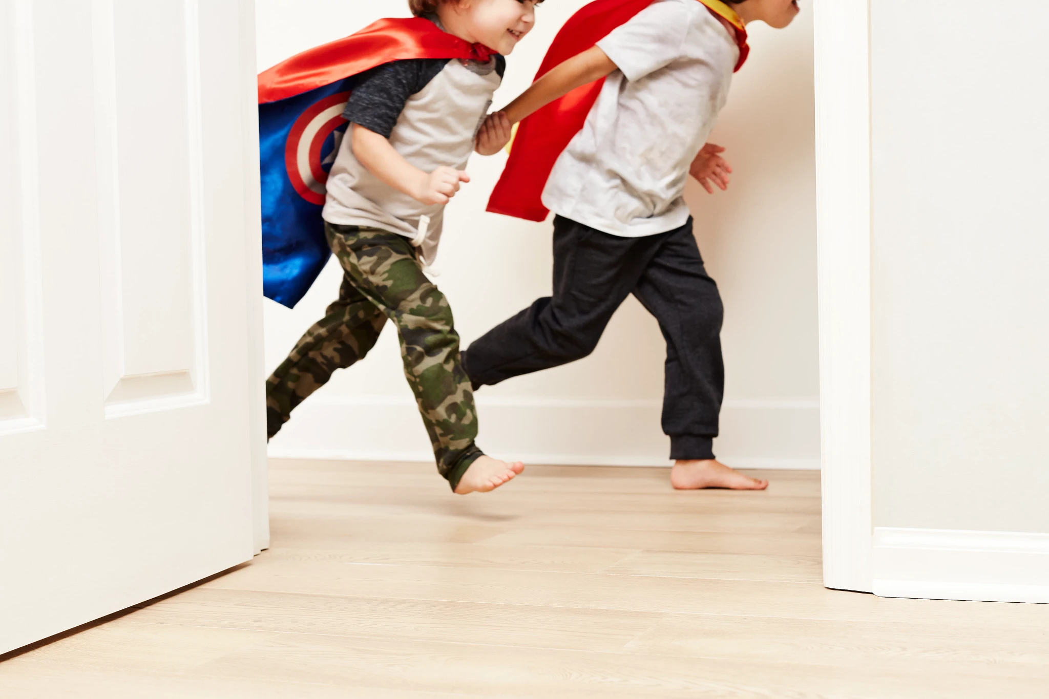 Children playing in a room with light wood flooring