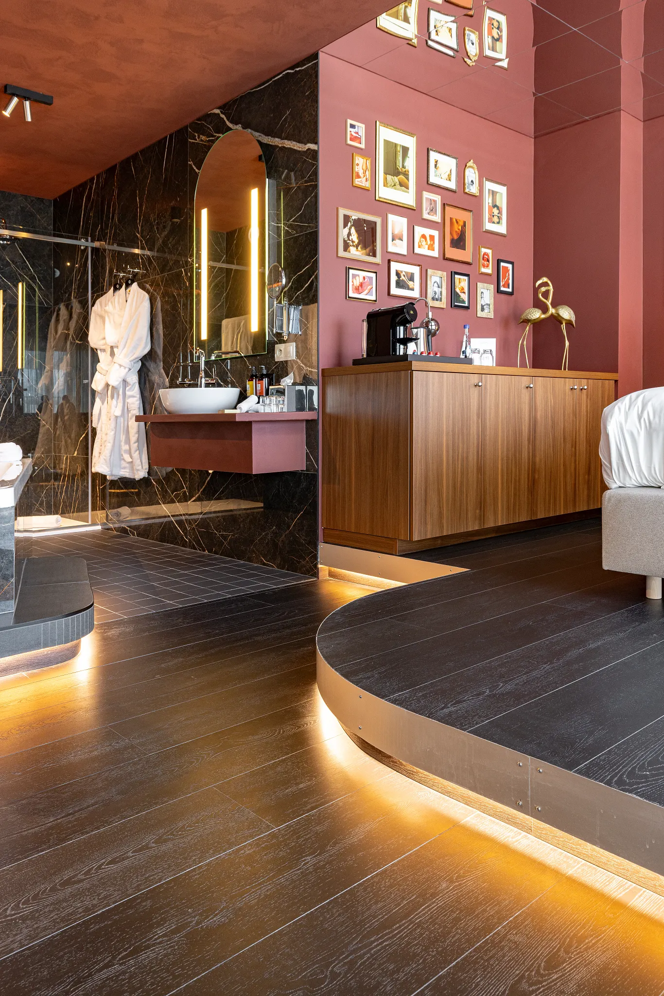 Dark and moody hotel room with connecting bathroom and black wooden Coretec floors