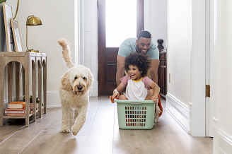 A man, a child and a dog enjoying a playful moment together on COREtec Scratchless flooring.