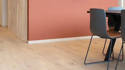 Stylish light wood flooring for contemporary dining spaces Light wood flooring in a modern dining area with coral accent wall