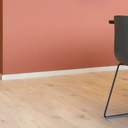 Stylish light wood flooring for contemporary dining spaces Light wood flooring in a modern dining area with coral accent wall